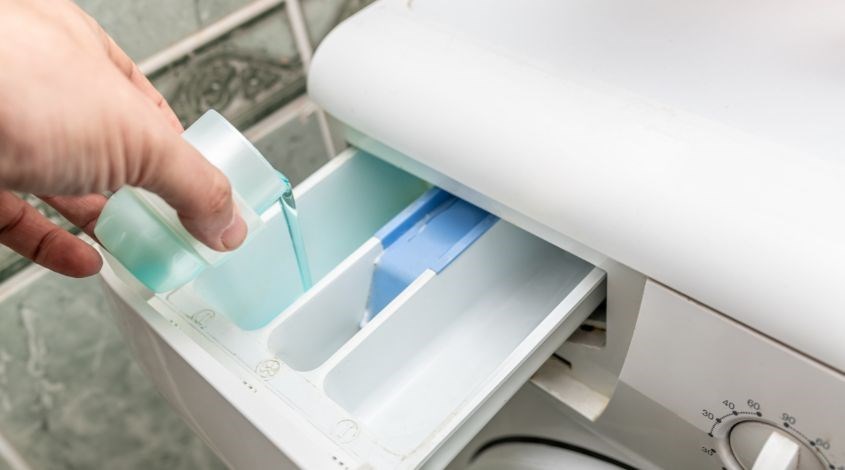 Cho nước giặt và nước xả thơm giày vào khay đựng