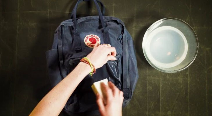 Nhúng bàn chải đánh răng vào hỗn hợp nước rửa chén và chà lên lớp ngoài của túi vải để vệ sinh được sạch hơn
