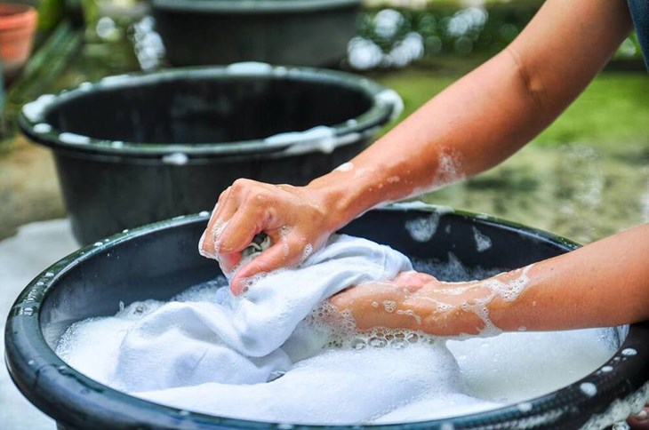 Sử dụng tay để nhẹ nhàng xoa bóp và xử lý các vết bẩn trên vải linen