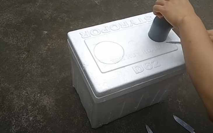Bạn dùng bút đánh dấu vẽ một đường tròn ở phần nắp thùng xốp sao cho bằng với đường kính của ống nhựa bạn đã chuẩn bị sẵn.