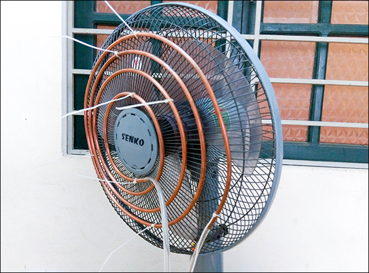 Bạn quấn ống đồng thành các hình tròn đồng tâm để gắn lên quạt. Sau đó, bạn cắt đoạn ống nhựa dẻo phi 6 thành 2 đoạn 70 cm và nối vào 2 đầu của ống đồng.