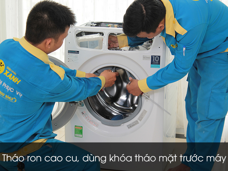 Dùng khóa tháo mặt trước máy ngay cửa lồng giặt