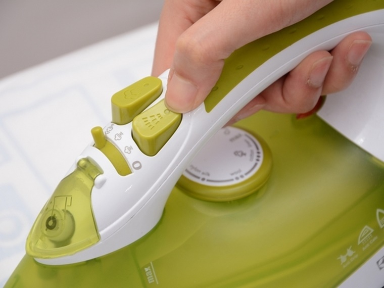 Nhấn nút phun tia để xịt nước ướt quần áo