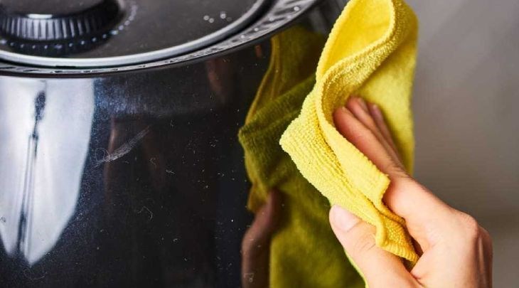 Lau sạch mặt ngoài bằng khăn ẩm để loại bỏ các vết dầu mỡ bám xung quanh