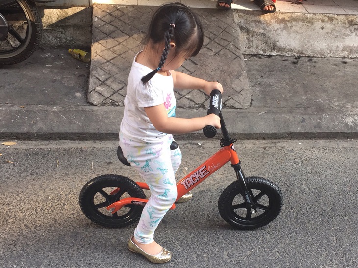 Hãy cho trẻ ngồi lên yên xe và hai tay nắm vững tay lái