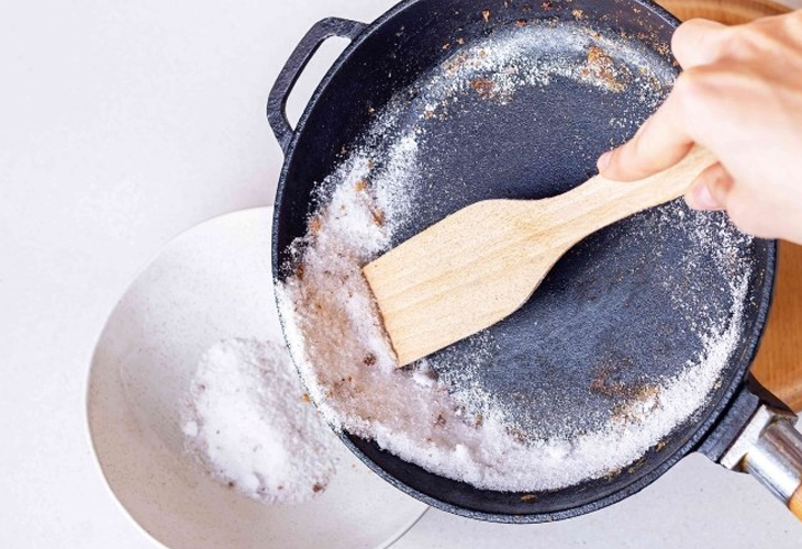 Cho dầu ăn và muối vào chảo, đun nóng khoảng 2 phút để loại bỏ vết bẩn