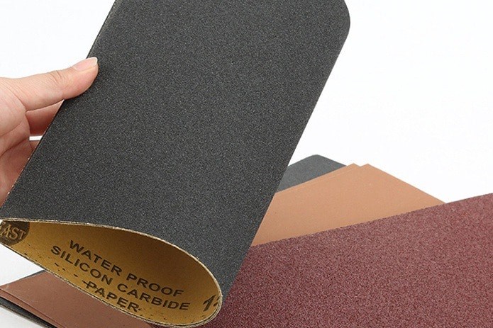 Bạn dùng giấy nhám chà nhẹ lên bề mặt giày để loại bỏ vết ẩm mốc